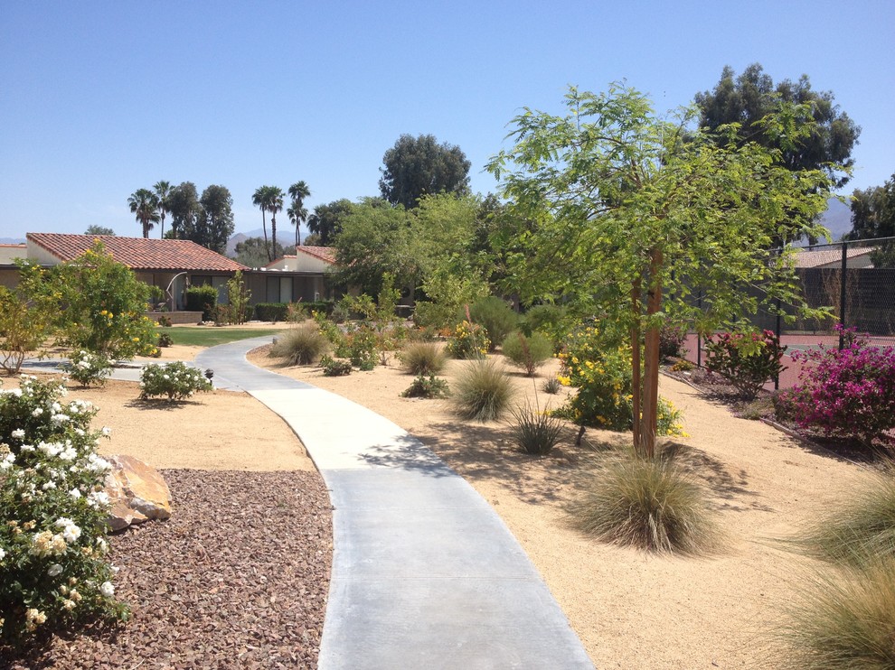 Photo of a mid-sized front yard full sun xeriscape for summer in Orange County with a garden path and concrete pavers.