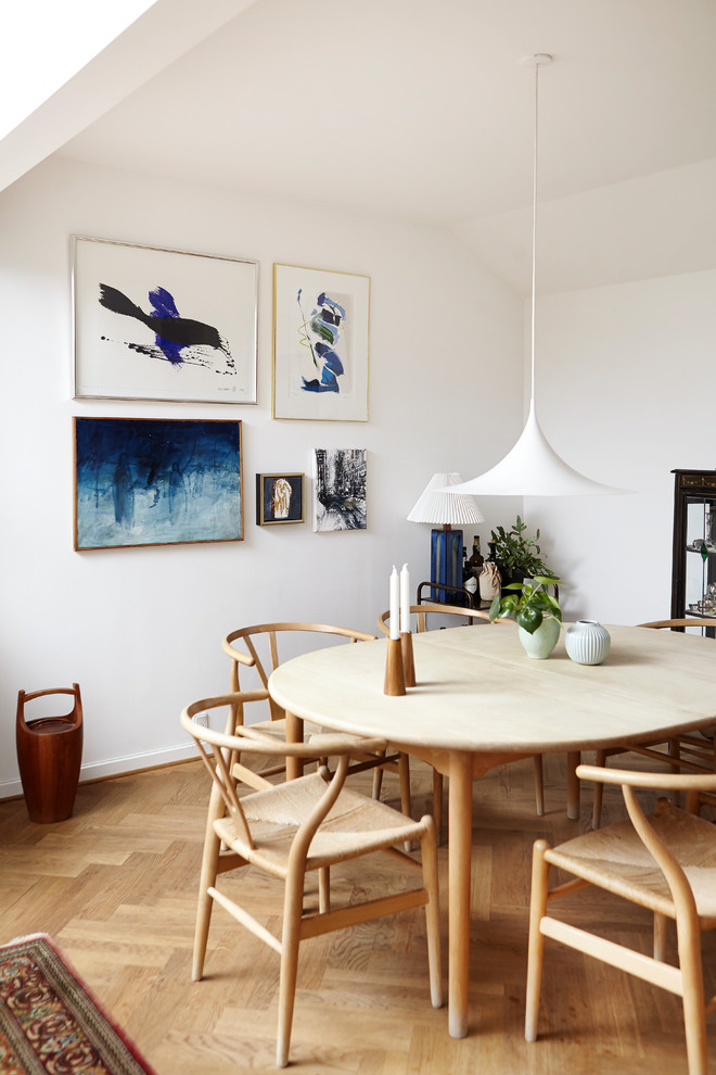 Scandinavian dining room in Aarhus with white walls, medium hardwood floors and beige floor.