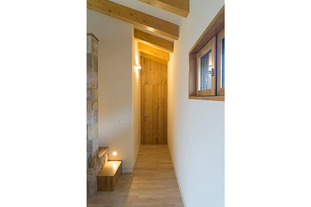 Design ideas for a small country hallway in Other with white walls, light hardwood floors and exposed beam.