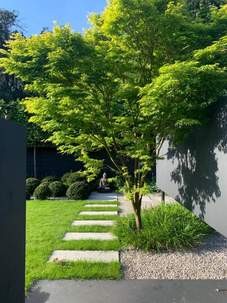 Réalisation d'un jardin arrière design de taille moyenne et l'été avec une exposition ensoleillée, des pavés en pierre naturelle et une clôture en bois.