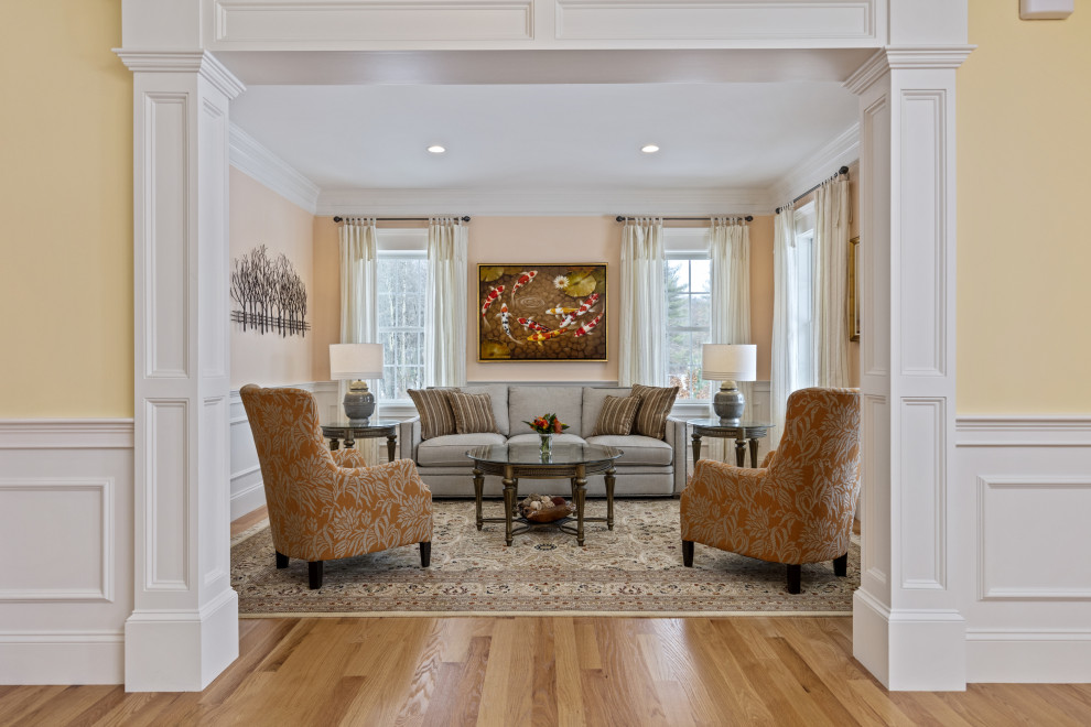 Photo of a mid-sized traditional enclosed living room in Boston with medium hardwood floors, brown floor, decorative wall panelling and orange walls.