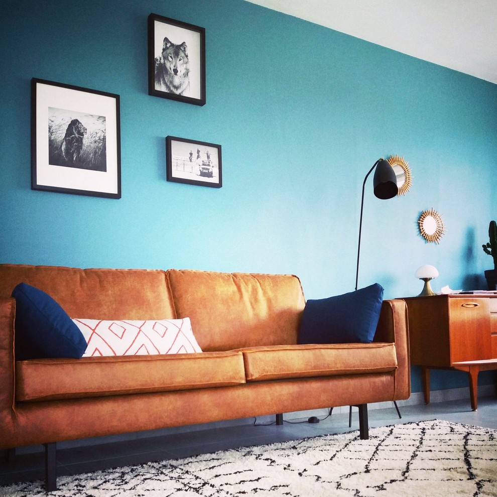This is an example of a mid-sized contemporary open concept living room in Lille with blue walls, ceramic floors, a freestanding tv and grey floor.