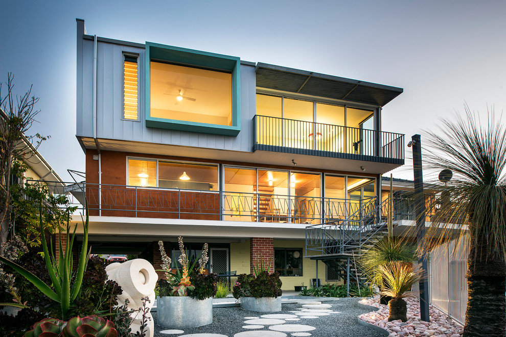 This is an example of a large midcentury three-storey grey exterior in Perth with mixed siding and a flat roof.