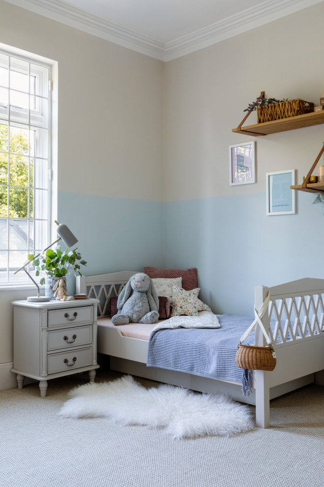Photo of a mid-sized traditional kids' room for girls in London with beige walls, carpet, beige floor, coffered and wallpaper.