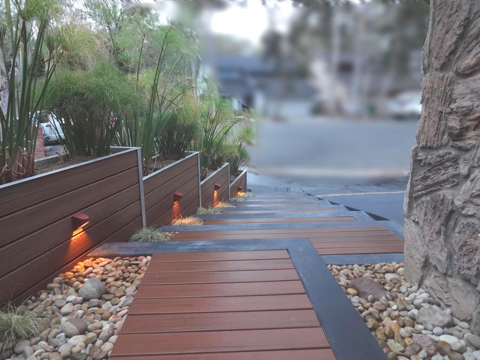 This is an example of a mid-sized asian front yard full sun driveway in Orange County with a garden path and decking.