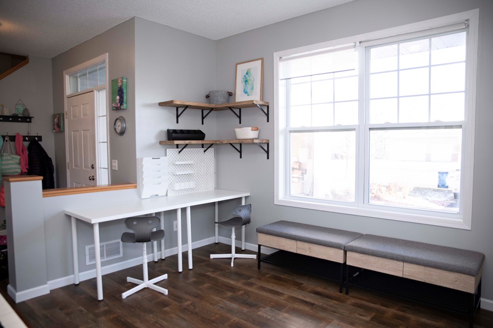 Small contemporary craft room in Minneapolis with grey walls, laminate floors, no fireplace, a freestanding desk and brown floor.