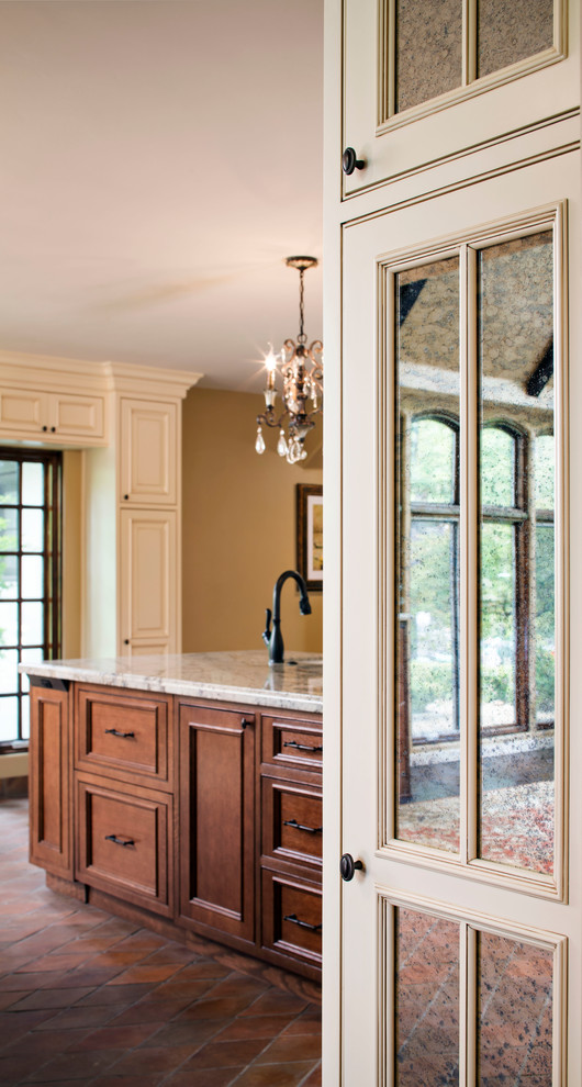 This is an example of a traditional kitchen in Sacramento with beaded inset cabinets, medium wood cabinets, granite benchtops, terra-cotta floors and multiple islands.
