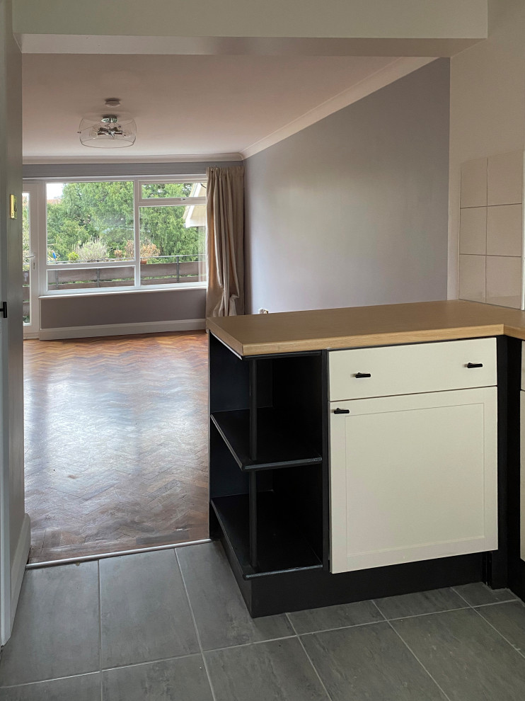 Inspiration for a small contemporary l-shaped open plan kitchen in London with an undermount sink, shaker cabinets, beige cabinets, laminate benchtops, beige splashback, ceramic splashback, stainless steel appliances, porcelain floors, a peninsula, pink floor and brown benchtop.