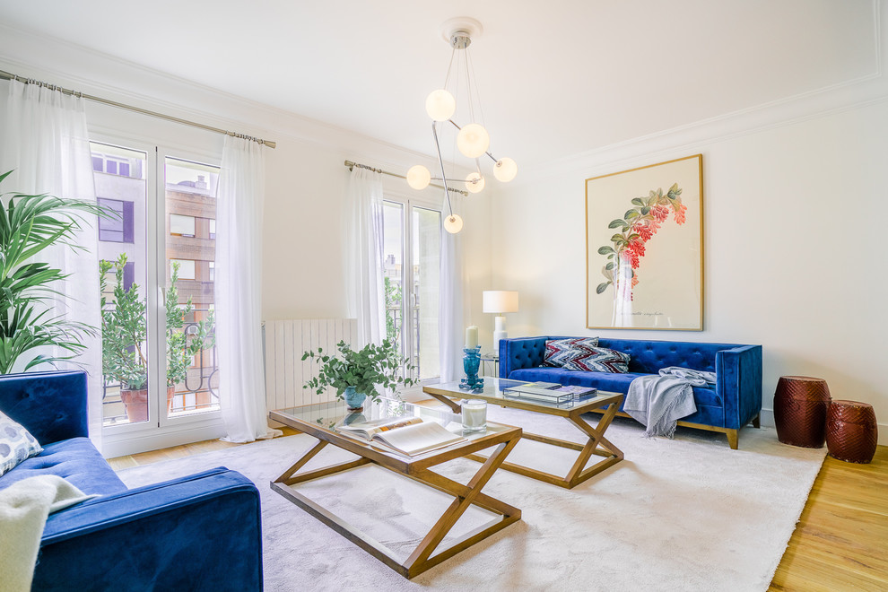 Inspiration for a mid-sized contemporary medium tone wood floor and brown floor living room remodel in Madrid with white walls