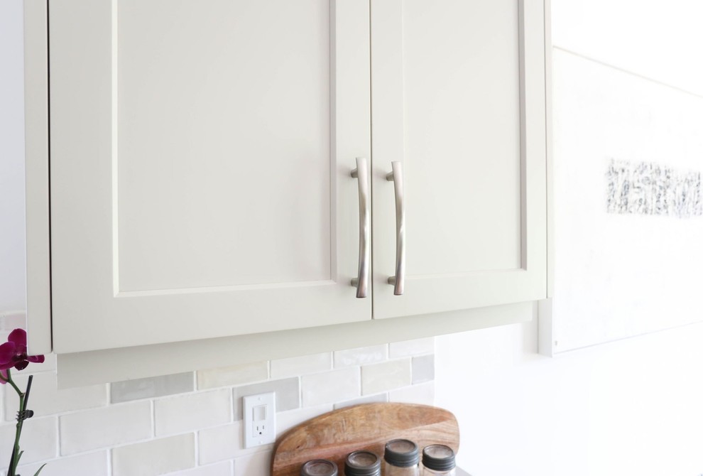 Mid-sized transitional l-shaped light wood floor and beige floor open concept kitchen photo with an integrated sink, shaker cabinets, blue cabinets, stainless steel countertops, ceramic backsplash, stainless steel appliances, an island and gray countertops