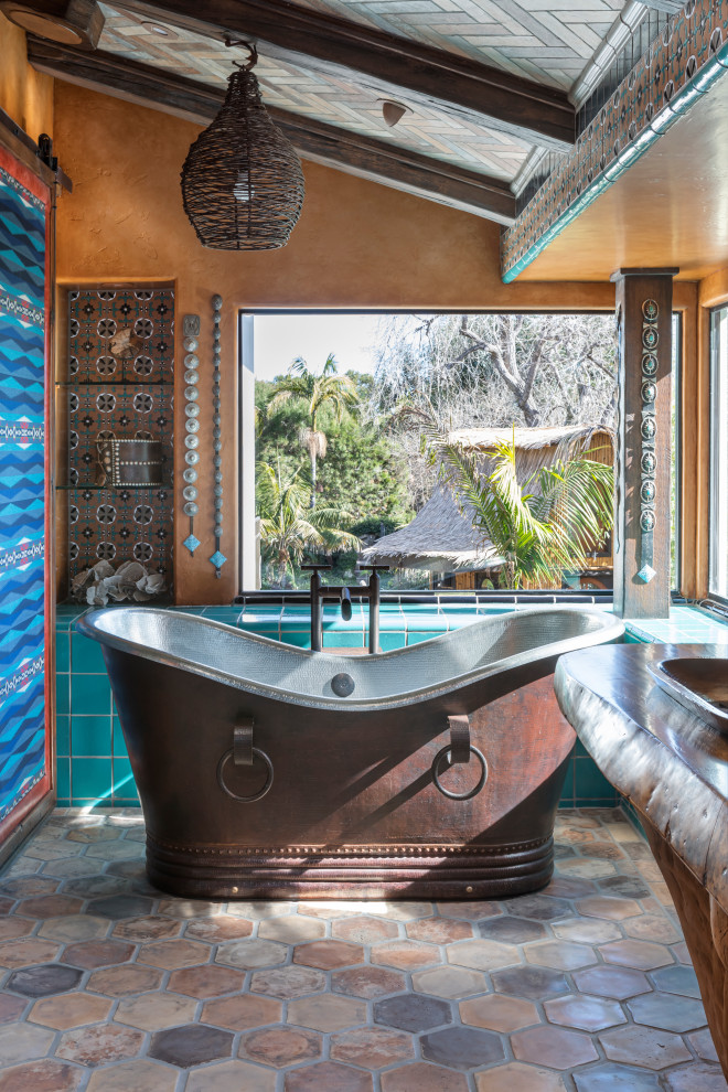 This is an example of a bathroom in Los Angeles with a freestanding tub, orange walls, brown floor and vaulted.