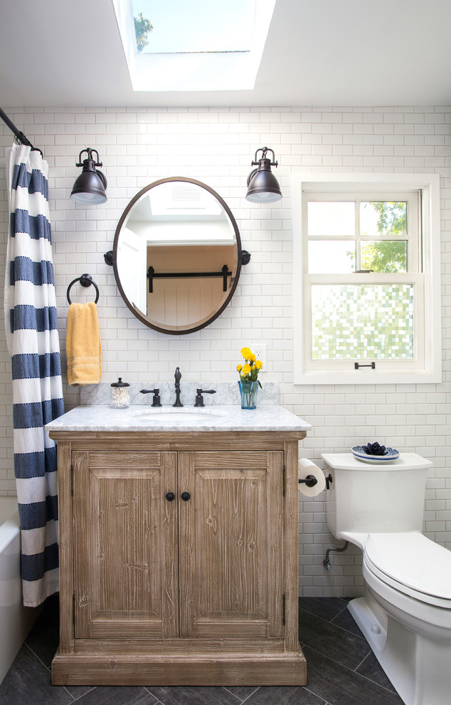 Design ideas for a beach style bathroom in Seattle with raised-panel cabinets, medium wood cabinets, a one-piece toilet, white tile, subway tile, white walls, an undermount sink, grey floor, a shower curtain and grey benchtops.