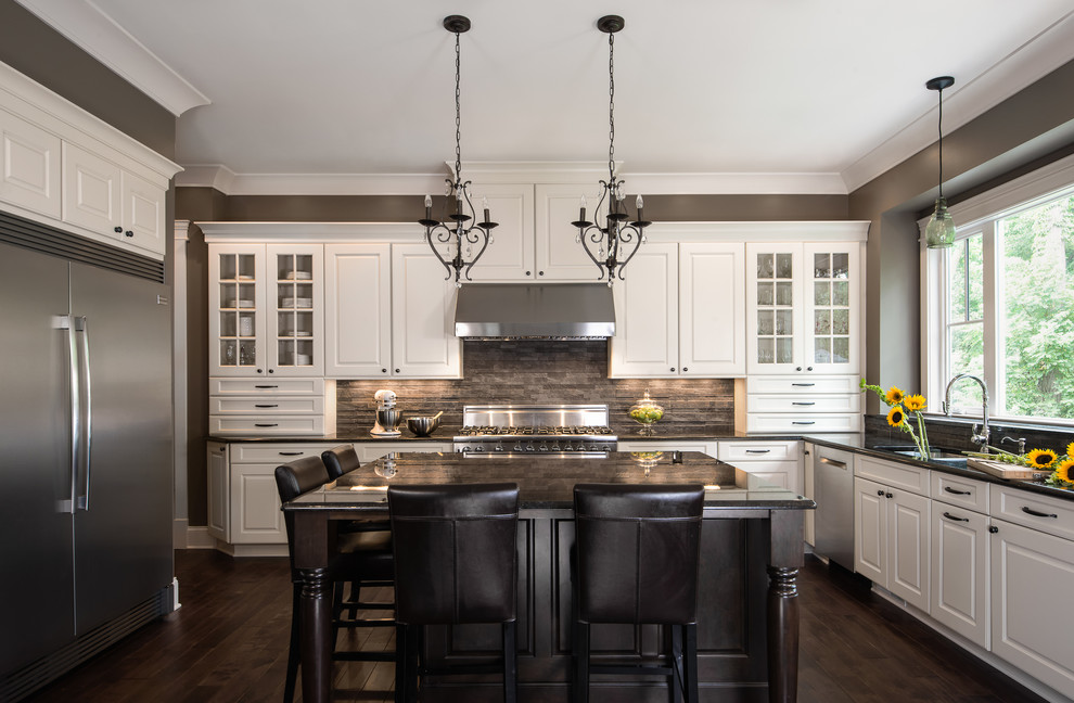 Design ideas for a large transitional l-shaped open plan kitchen in Detroit with an undermount sink, raised-panel cabinets, white cabinets, granite benchtops, grey splashback, stone tile splashback, stainless steel appliances, dark hardwood floors and with island.