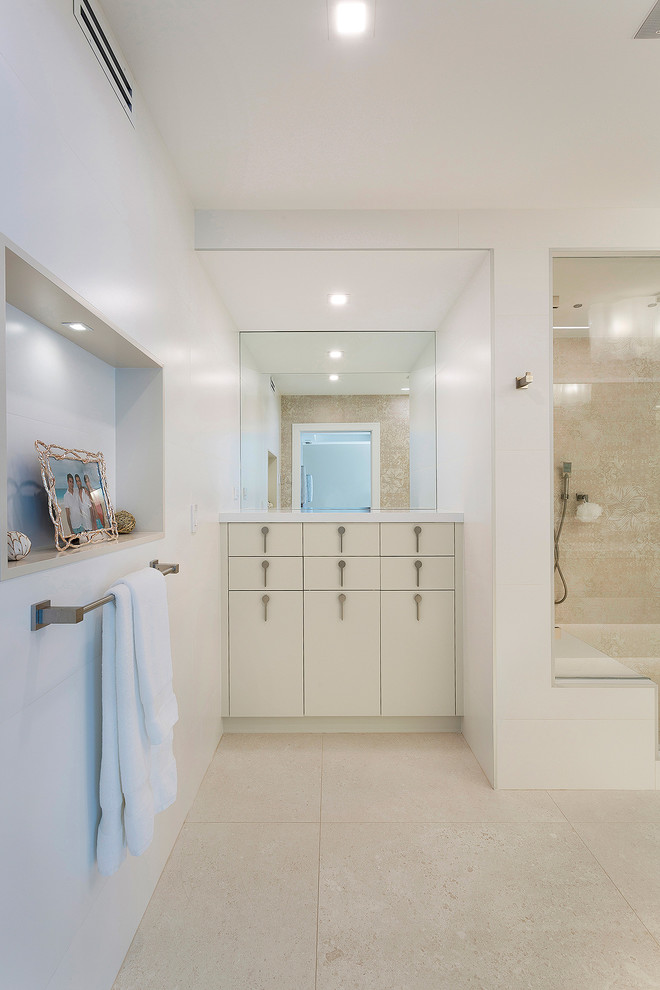 Inspiration for a mid-sized contemporary master bathroom in Miami with flat-panel cabinets, beige cabinets, an alcove shower, a one-piece toilet, beige tile, ceramic tile, beige walls, cement tiles, solid surface benchtops, beige floor, a hinged shower door and white benchtops.