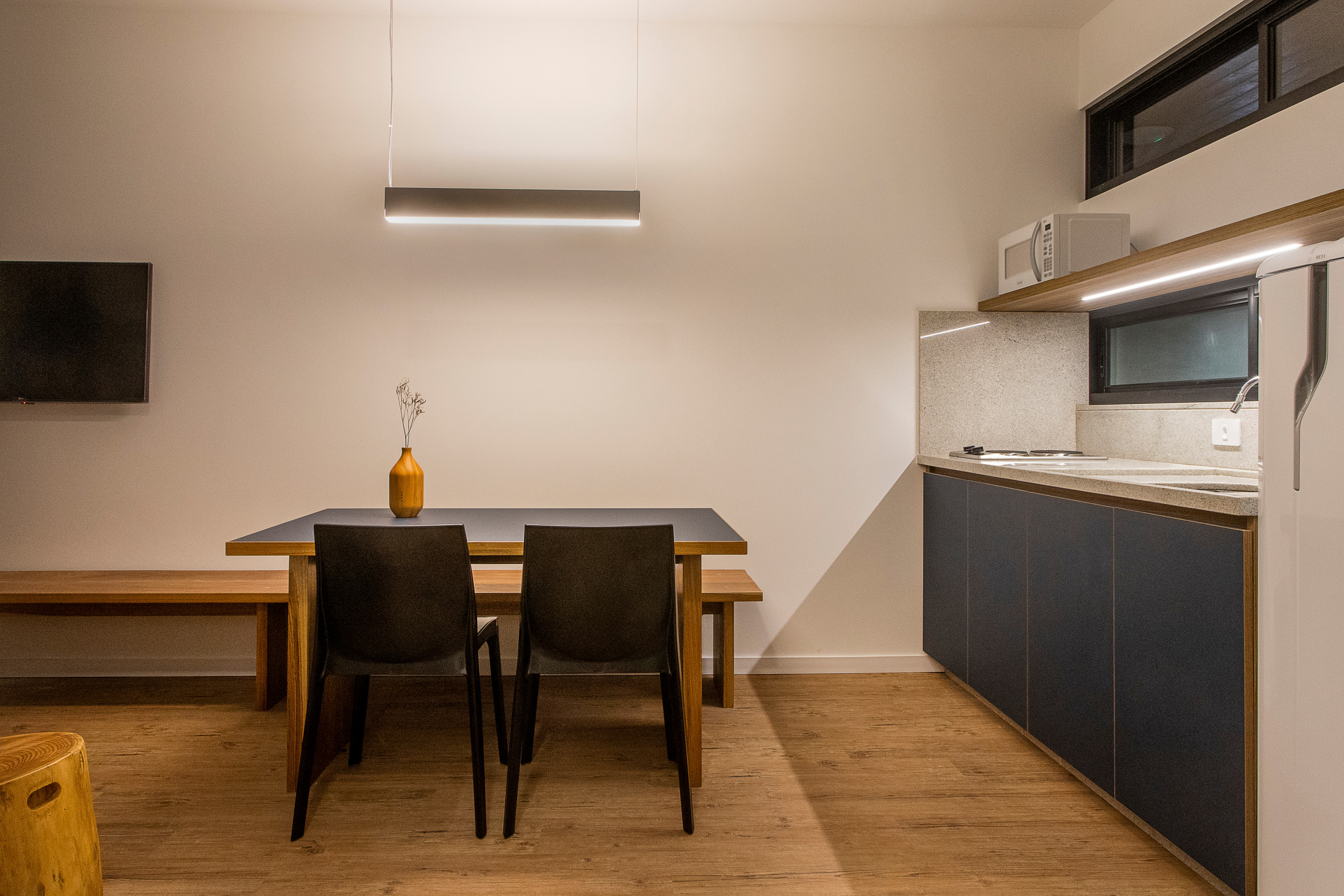 Cocina integrada en el salón con estantería en madera