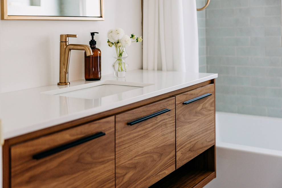 This is an example of a small midcentury master bathroom in Detroit with flat-panel cabinets, brown cabinets, a drop-in tub, blue tile, ceramic tile, ceramic floors, engineered quartz benchtops, white floor, white benchtops, a single vanity and a floating vanity.