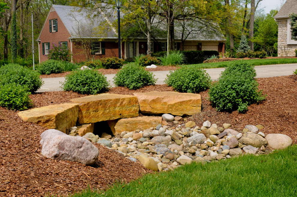 This is an example of a large traditional front yard full sun xeriscape in Columbus with with rock feature.