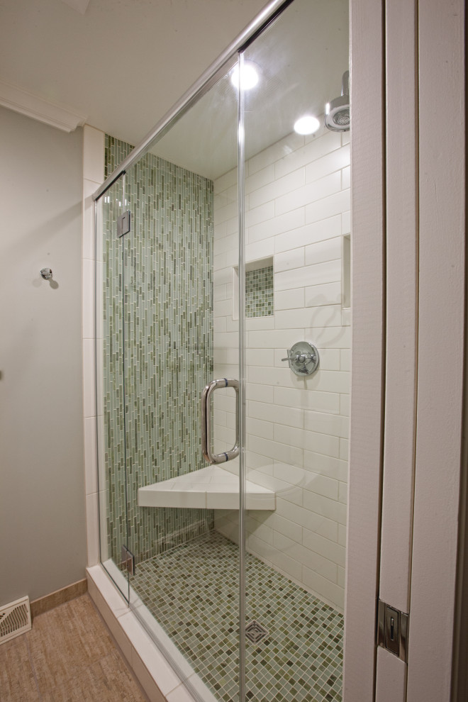 Стильный дизайн: ванная комната в стиле неоклассика (современная классика) с фасадами с утопленной филенкой, зелеными фасадами, душем в нише, раздельным унитазом, зеленой плиткой, стеклянной плиткой, полом из керамической плитки, настольной раковиной, столешницей из бетона, бежевым полом, душем с распашными дверями, бежевой столешницей, сиденьем для душа, тумбой под две раковины и встроенной тумбой - последний тренд