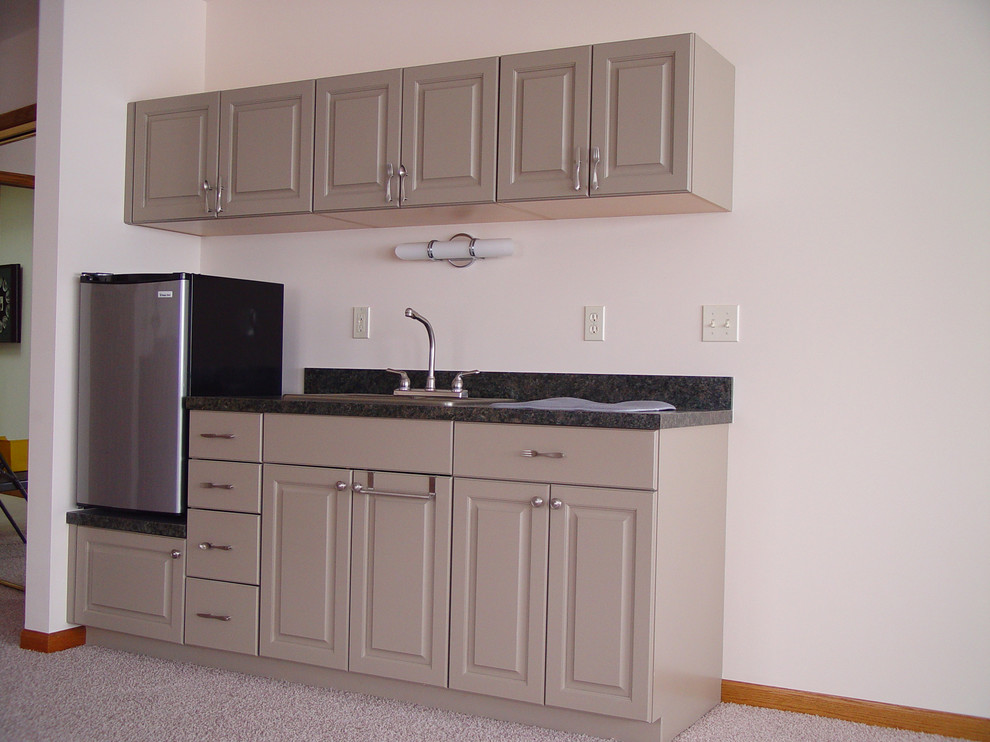 Photo of a small traditional single-wall eat-in kitchen in Chicago with a drop-in sink, raised-panel cabinets, grey cabinets, laminate benchtops, stainless steel appliances and carpet.