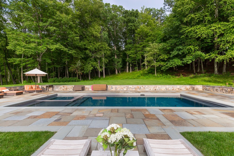 Mid-sized transitional backyard rectangular lap pool in New York with a hot tub and natural stone pavers.