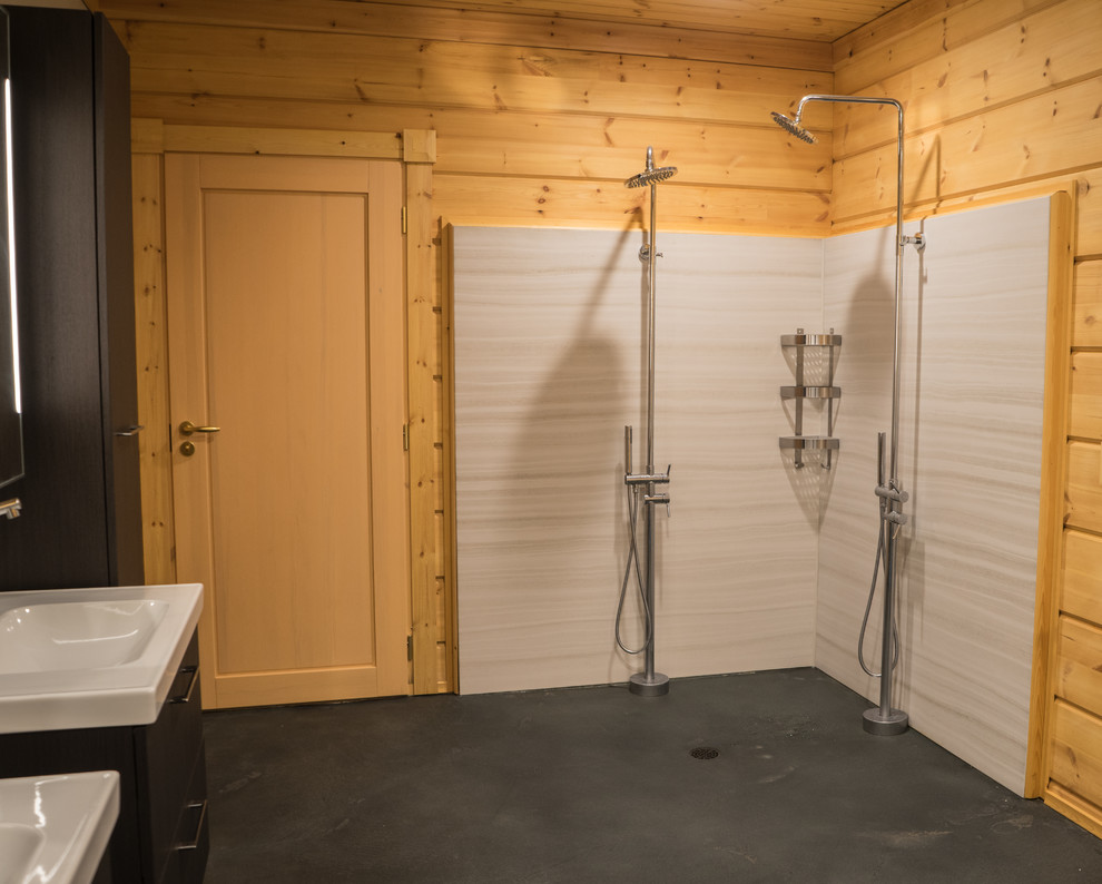 Example of a large mountain style master concrete floor and gray floor doorless shower design with flat-panel cabinets, dark wood cabinets, an integrated sink and beige walls