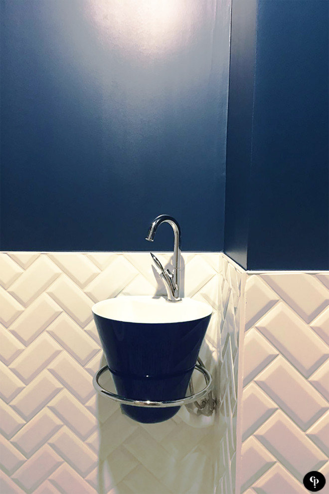 Foto di un piccolo bagno di servizio minimal con WC sospeso, piastrelle bianche, piastrelle diamantate, pareti blu, pavimento con piastrelle in ceramica, lavabo sospeso e pavimento nero