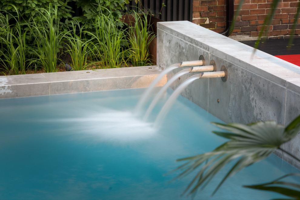 Стильный дизайн: прямоугольный бассейн среднего размера на заднем дворе в стиле лофт с фонтаном и настилом - последний тренд