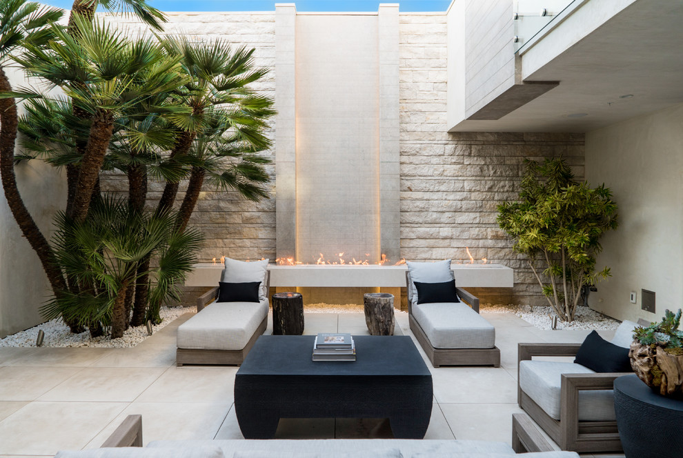 Photo of a large contemporary courtyard patio in Phoenix with tile, no cover and with fireplace.