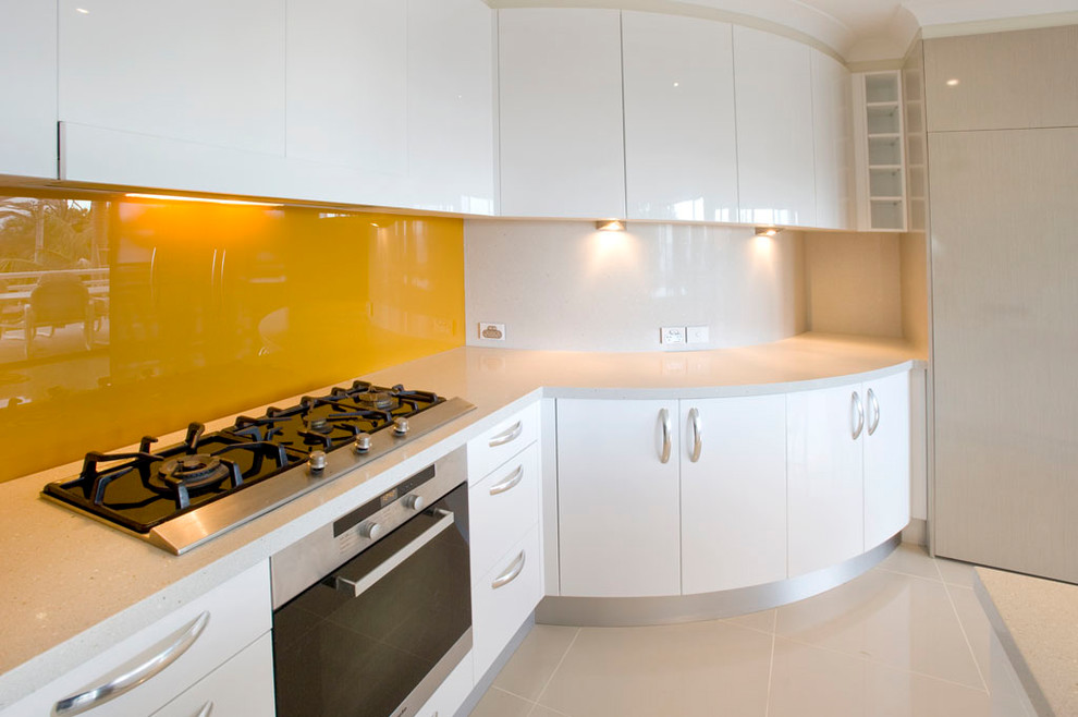 Mid-sized transitional single-wall porcelain tile and beige floor enclosed kitchen photo in DC Metro with flat-panel cabinets, white cabinets, quartz countertops, yellow backsplash, glass sheet backsplash and paneled appliances