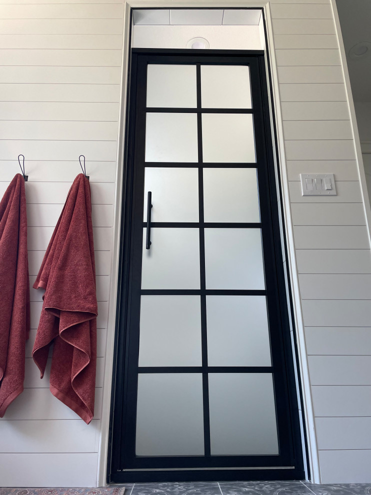 Example of a large transitional master pebble tile floor, gray floor and double-sink freestanding bathtub design with light wood cabinets, a two-piece toilet, white walls, a drop-in sink, wood countertops, a hinged shower door, brown countertops, a niche and a freestanding vanity