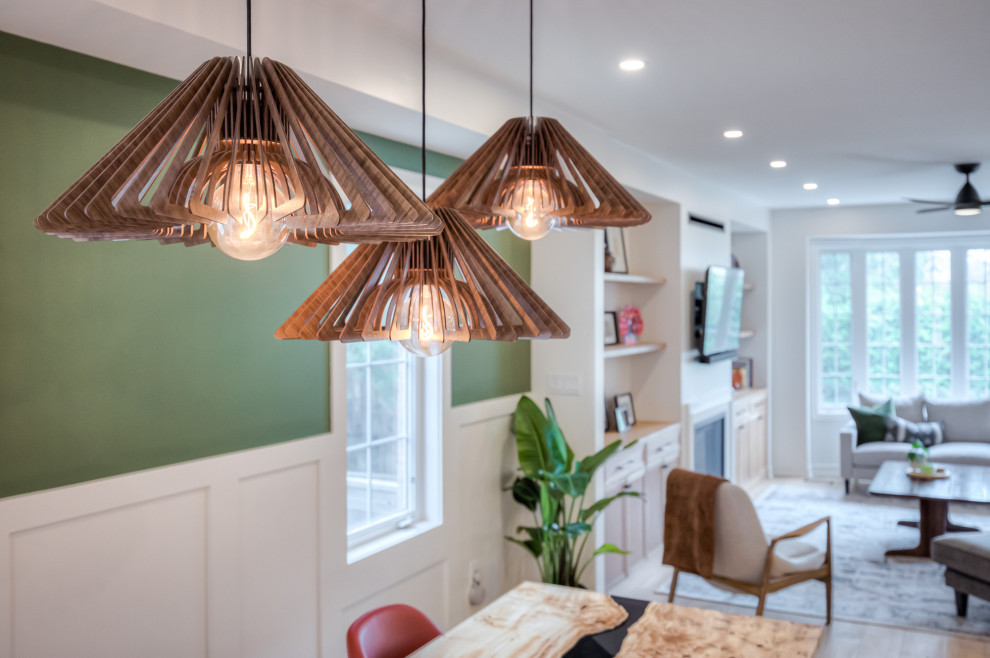 Стильный дизайн: кухня-столовая в скандинавском стиле с зелеными стенами, светлым паркетным полом, стандартным камином, фасадом камина из дерева, бежевым полом и панелями на стенах - последний тренд