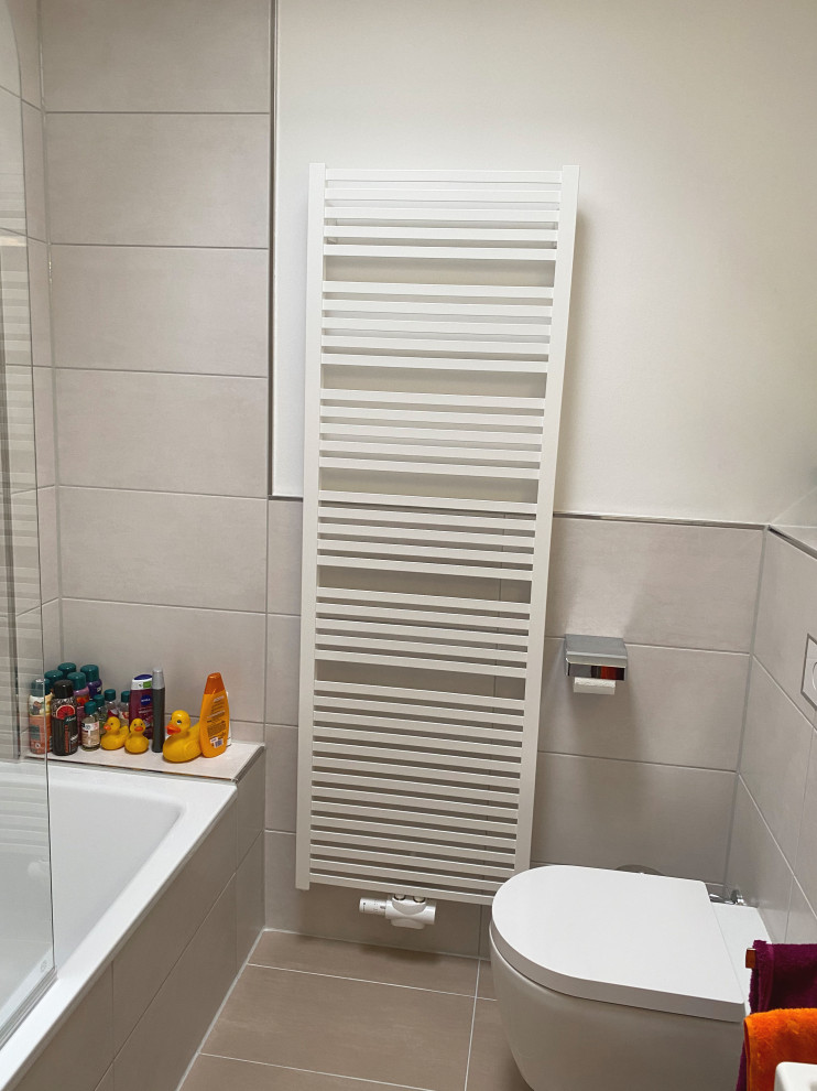 Small modern shower room bathroom in Other with flat-panel cabinets, medium wood cabinets, a built-in bath, a shower/bath combination, a wall mounted toilet, beige tiles, porcelain tiles, white walls, porcelain flooring, wooden worktops, beige floors, a hinged door, white worktops, double sinks and a freestanding vanity unit.