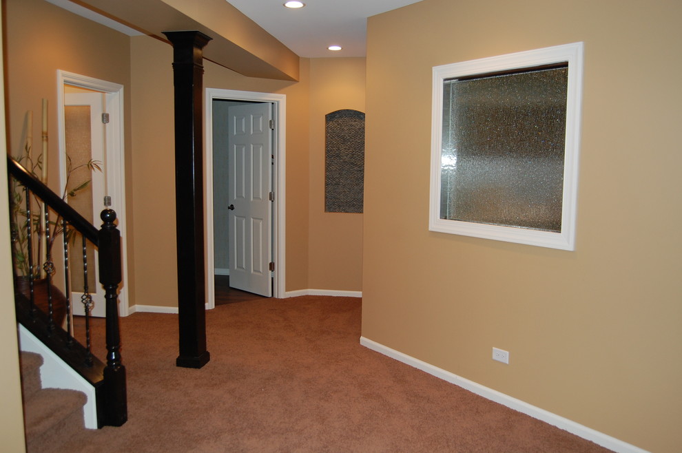 Home design - large transitional underground carpeted home design idea in Chicago with yellow walls, a ribbon fireplace and a metal fireplace