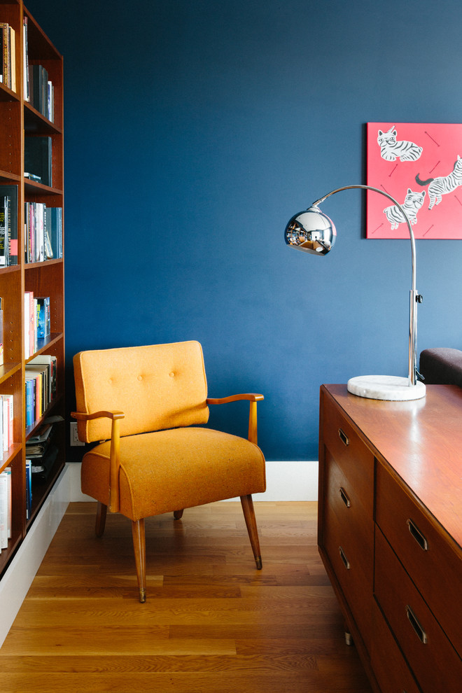 Ispirazione per una camera matrimoniale design con pareti blu e parquet chiaro