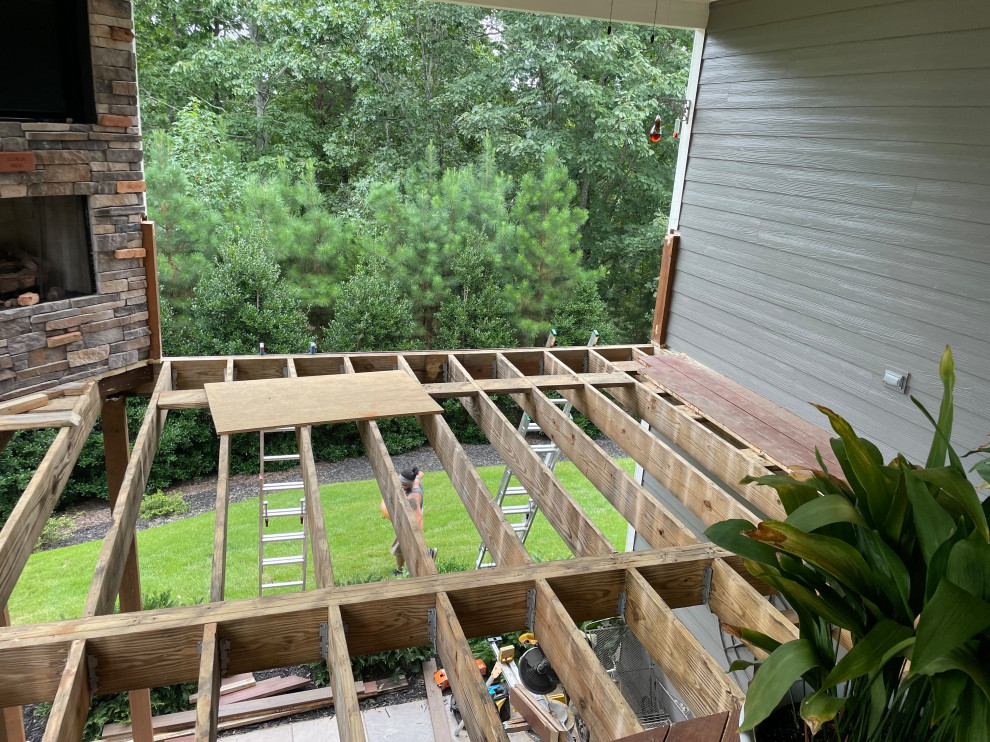 Deck - mid-sized modern backyard second story metal railing deck idea with a roof extension