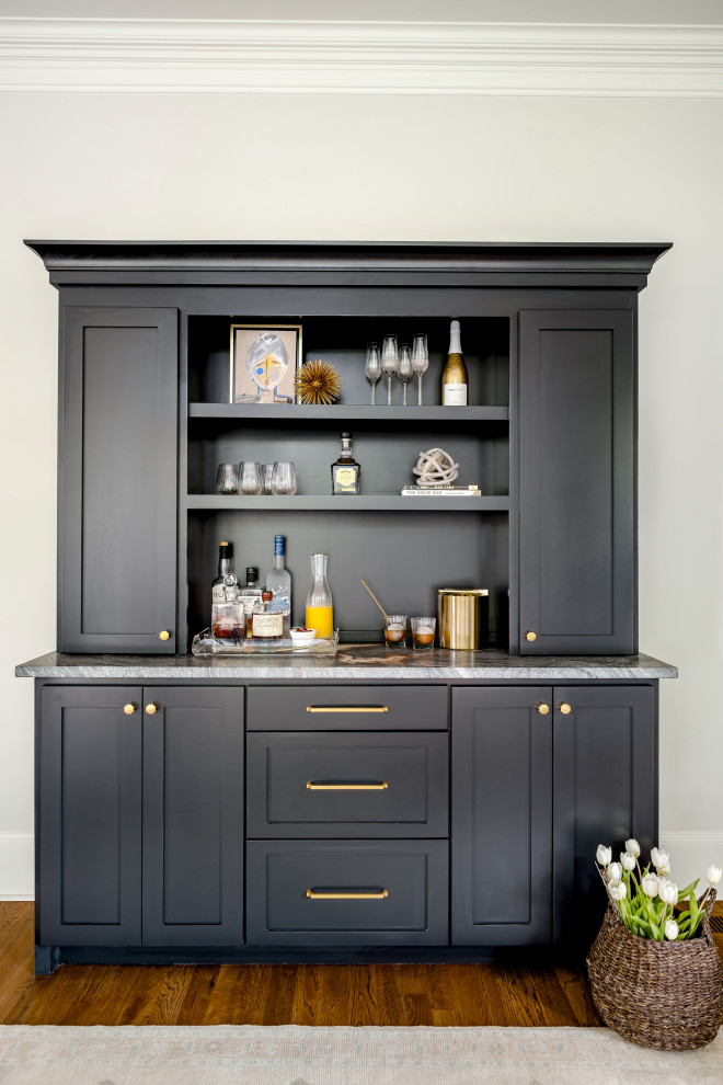 Photo of a small transitional single-wall home bar in Charlotte with no sink, shaker cabinets, black cabinets, quartzite benchtops, black splashback, timber splashback, medium hardwood floors, brown floor and black benchtop.