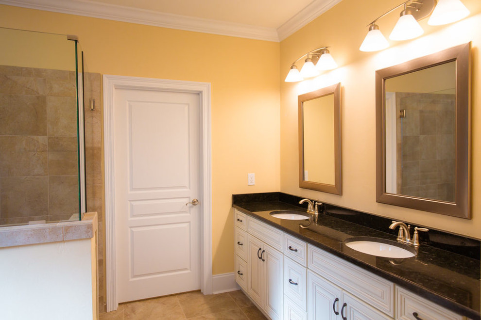 Inspiration for a mid-sized traditional master bathroom in Orange County with raised-panel cabinets, white cabinets, a hot tub, a corner shower, beige tile, ceramic tile, yellow walls, ceramic floors, an undermount sink and solid surface benchtops.
