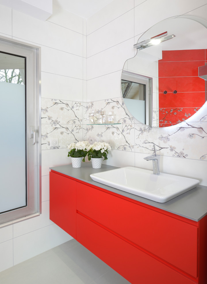 Small modern master bathroom in Angers with flat-panel cabinets, red cabinets, a curbless shower, ceramic tile, grey benchtops, a single vanity, a floating vanity, white walls, a trough sink, grey floor, a hinged shower door and white tile.
