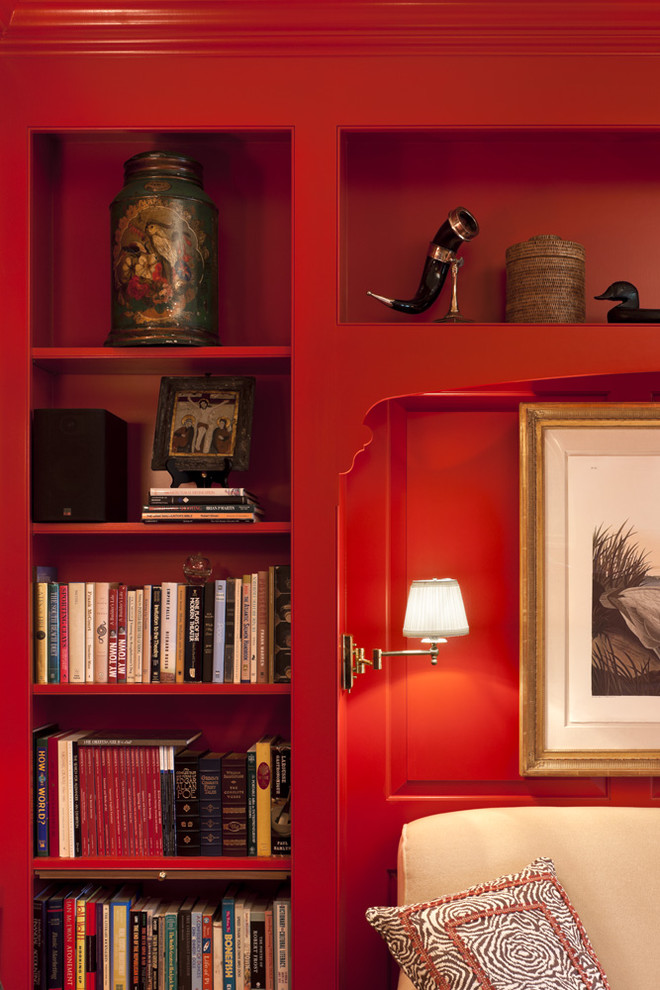 This is an example of a mid-sized traditional open concept living room in Philadelphia with a library, red walls, carpet, a standard fireplace, a metal fireplace surround and no tv.