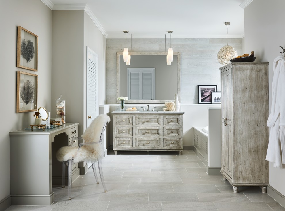 Photo of a large transitional master bathroom in Minneapolis with distressed cabinets, a drop-in tub, recessed-panel cabinets, beige tile, grey walls, an undermount sink and beige floor.