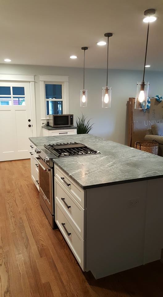 Inspiration for a large transitional l-shaped medium tone wood floor open concept kitchen remodel in Baltimore with shaker cabinets, white cabinets, an island, soapstone countertops, multicolored backsplash, matchstick tile backsplash and stainless steel appliances