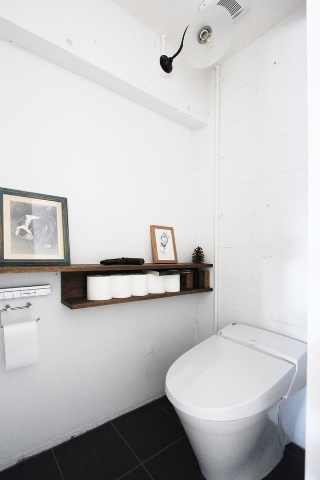 Inspiration for a scandinavian powder room in Tokyo with white walls and black floor.