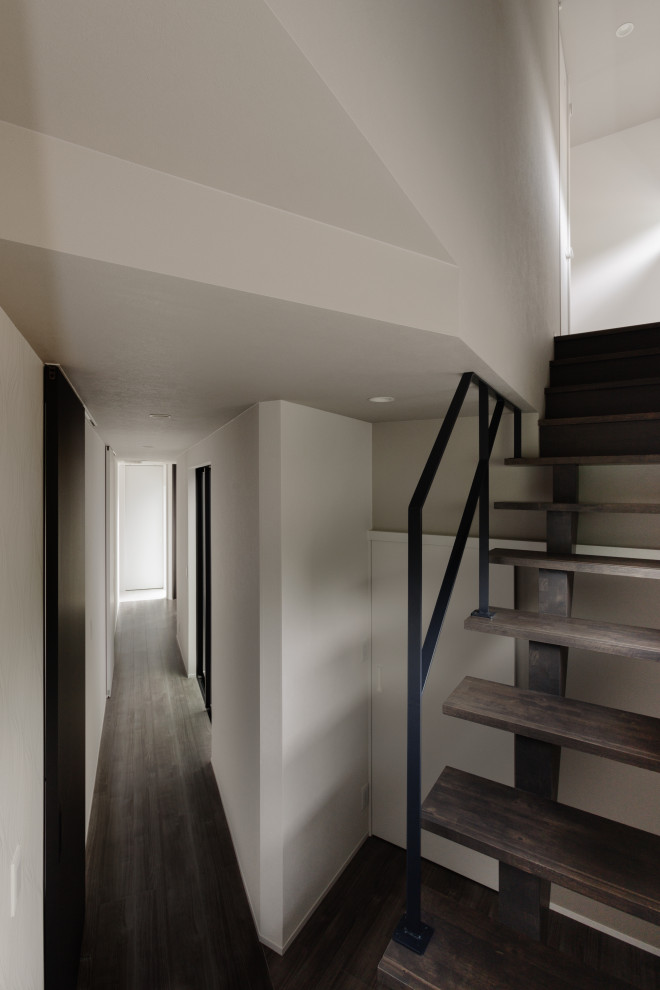Aménagement d'un escalier sans contremarche droit moderne avec des marches en bois, un garde-corps en métal, du papier peint et palier.