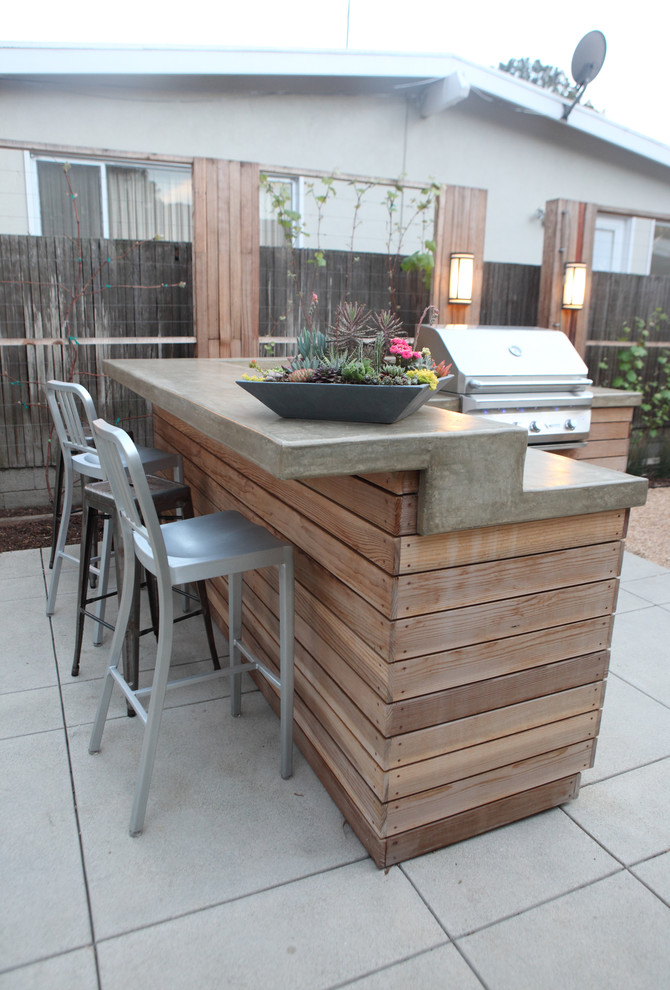 Large beach style backyard patio in Los Angeles with an outdoor kitchen and concrete pavers.
