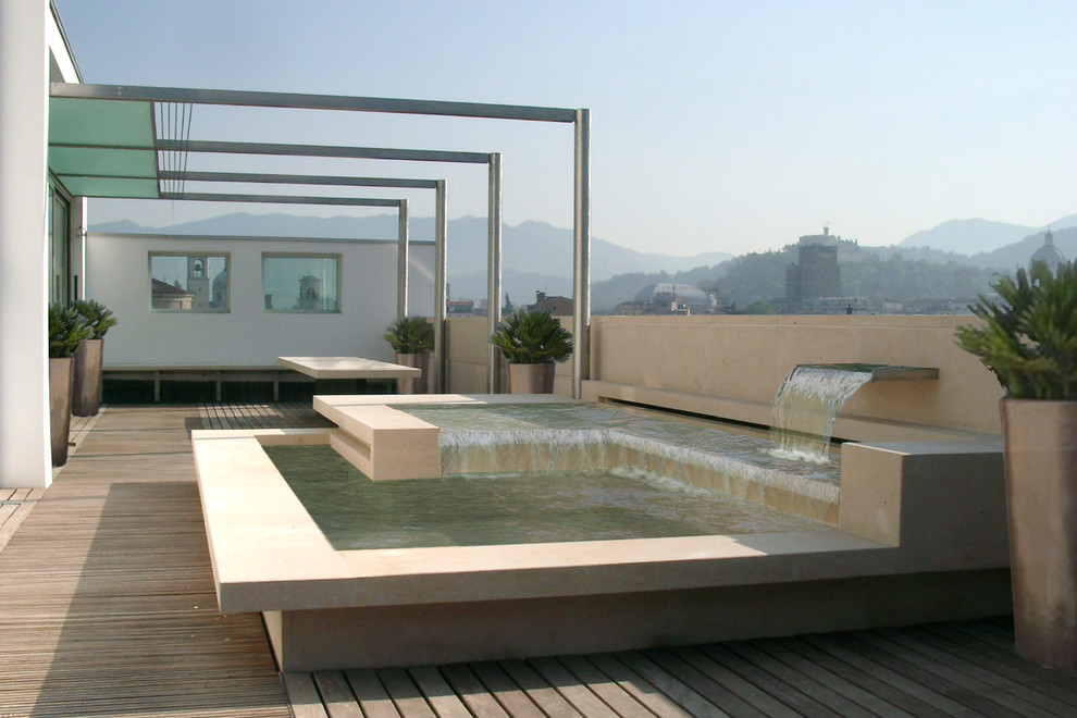 Inspiration for a contemporary rooftop and rooftop deck in Milan with a water feature and a pergola.