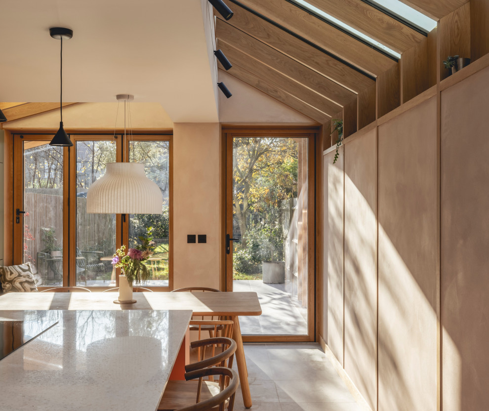 Aménagement d'une grande cuisine américaine parallèle scandinave en bois clair avec un placard sans porte, un plan de travail en surface solide, îlot et un plan de travail blanc.