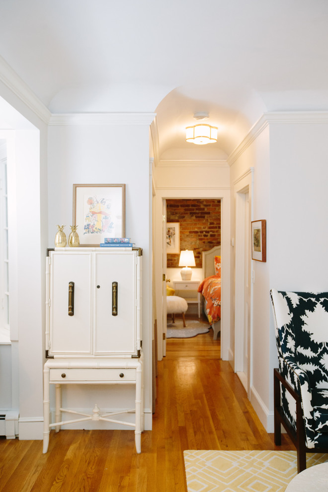 Small contemporary hallway in Boston with white walls, medium hardwood floors and brown floor.