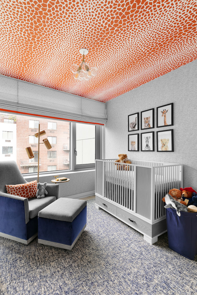 Ejemplo de habitación de bebé contemporánea pequeña con paredes azules, suelo de madera clara y papel pintado