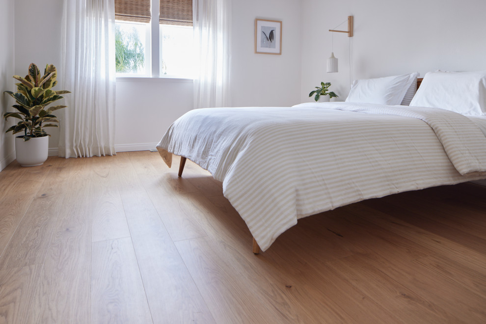 Imagen de dormitorio principal vintage de tamaño medio con paredes blancas, suelo de madera clara y suelo marrón