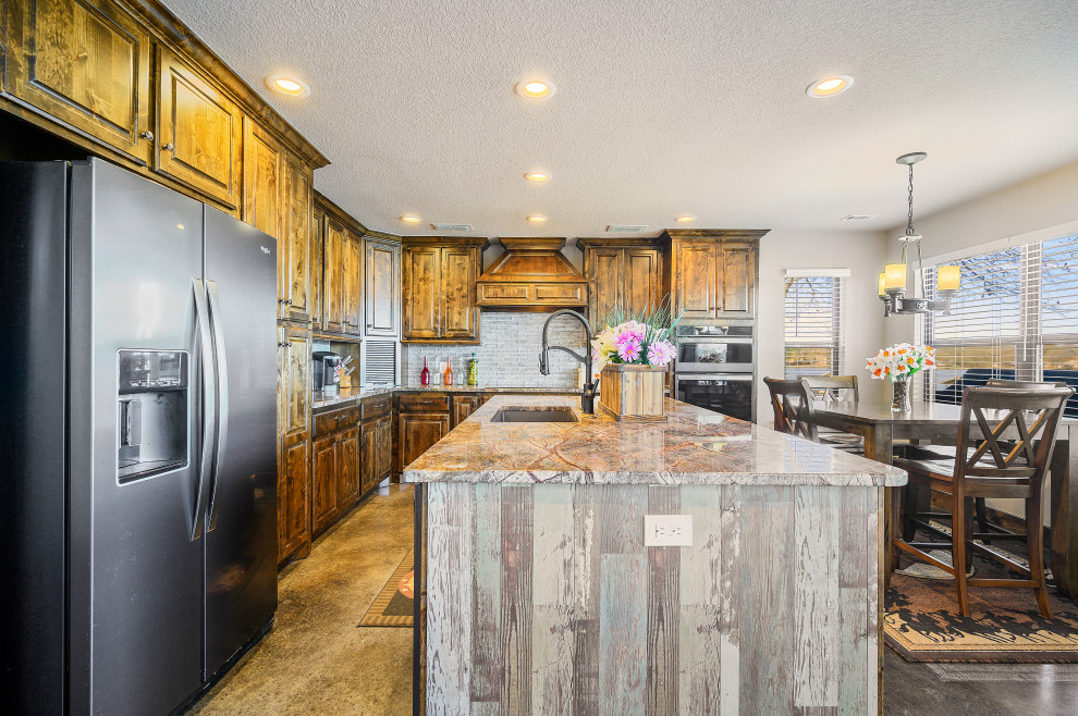 Foto på ett mellanstort rustikt brun kök, med en nedsänkt diskho, luckor med profilerade fronter, skåp i mellenmörkt trä, granitbänkskiva, vitt stänkskydd, stänkskydd i stenkakel, rostfria vitvaror, vinylgolv, en köksö och svart golv